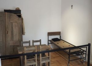 Drewniane rekwizyty: stół z krzesłami, łóżko i szafa