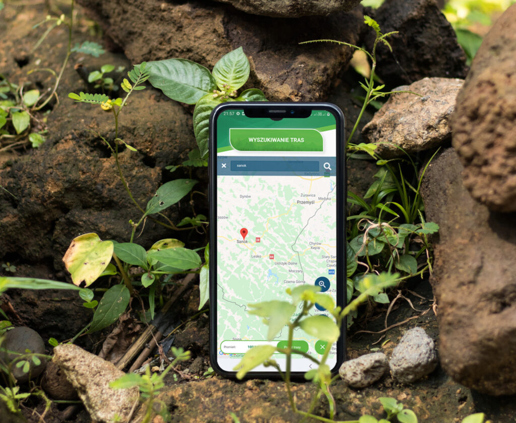 smartfon ołożony na ziemi wśród zieleni z otwartą aplikacją Bieszczadzka droga